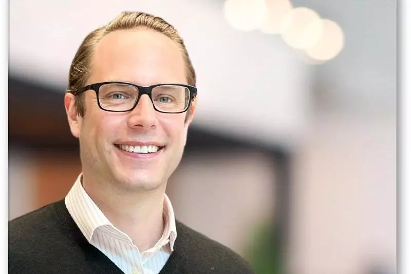 Man wearing glasses smiling into camera